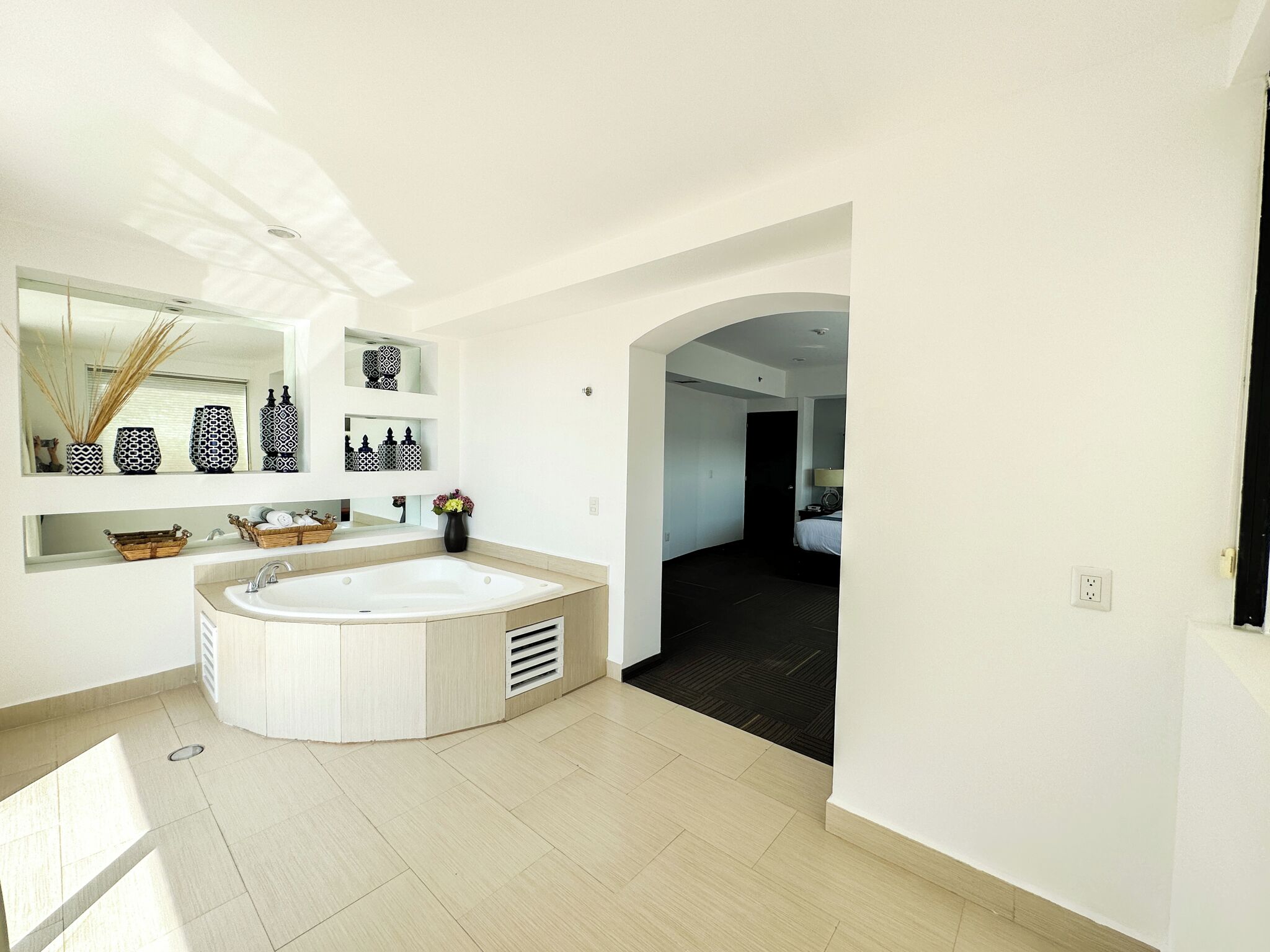 A modern bathroom with a large bathtub, a vanity with a mirror, and a shower area.