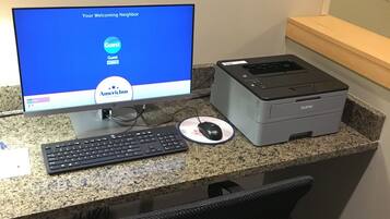 A computer desk with a monitor, keyboard, mouse, and printer.