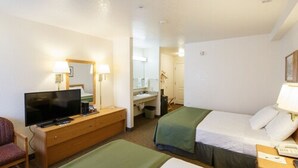 A hotel room with a bed, a TV, a desk, and a chair. - Murphys Inn Motel (Murphys)