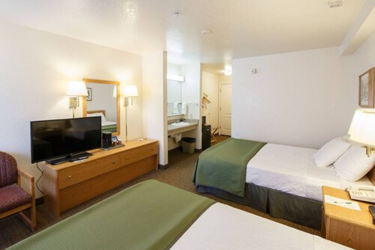 Une chambre d’hôtel avec un lit, une télévision, un bureau et une chaise.