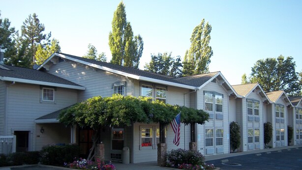A motel with a covered entrance, American flag, and a sign that reads "ACANNY". - Murphys Inn Motel (Murphys)