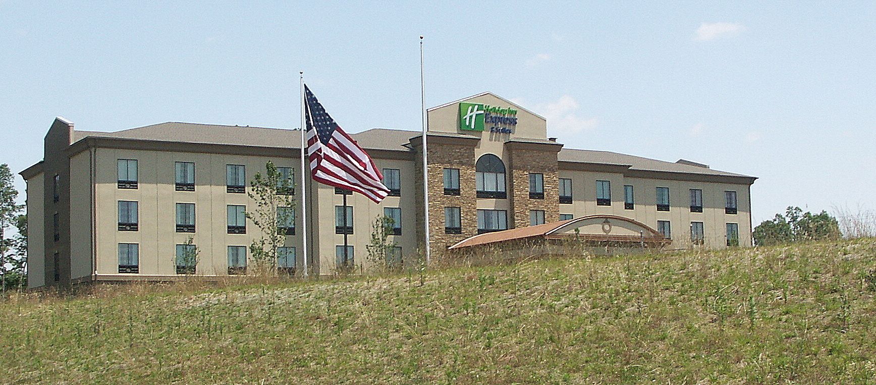 A hotel with a flat roof, multiple windows, and an American flag.