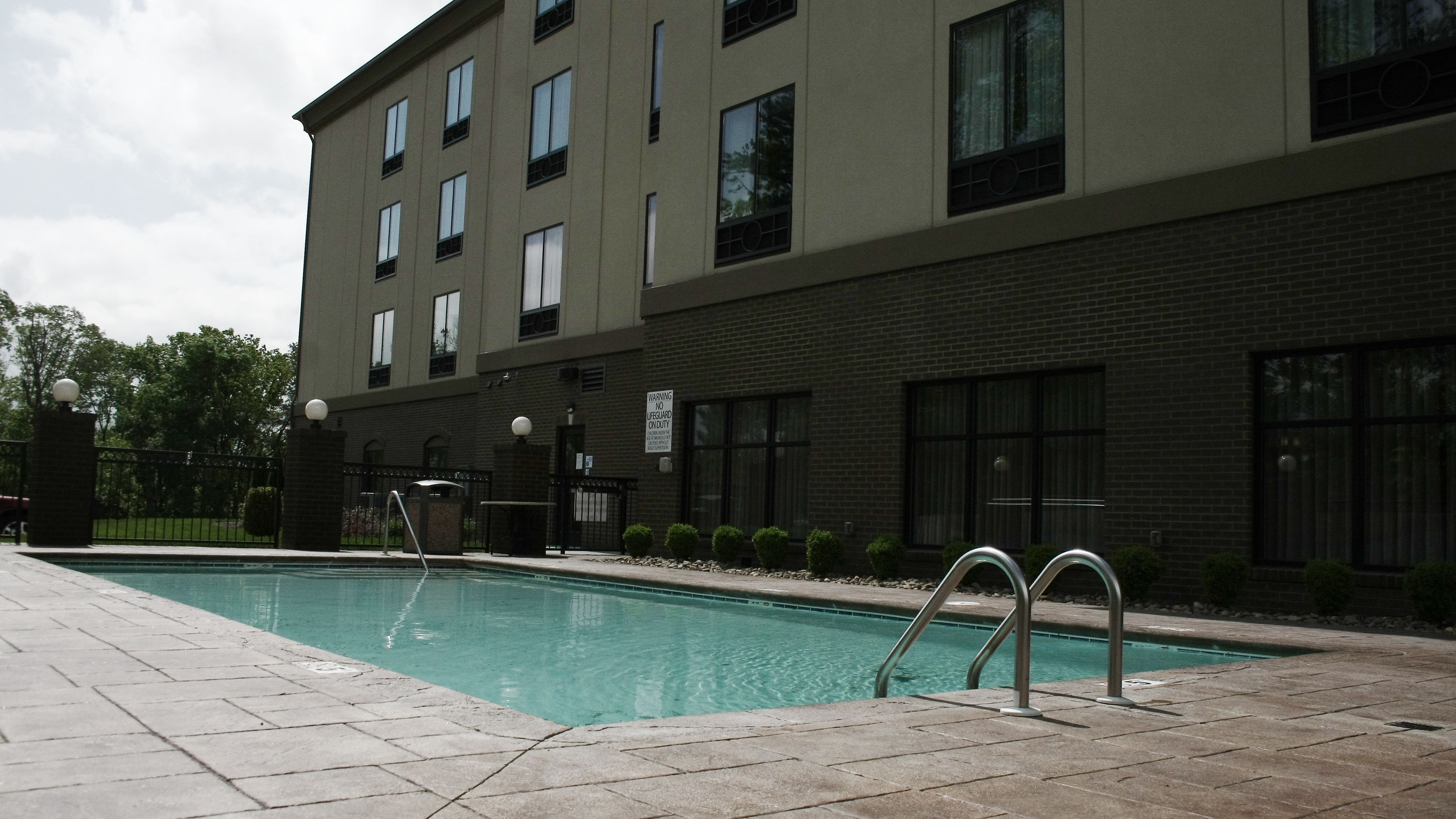 A swimming pool with a brick building in the background.