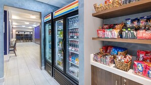 A modern retail space with refrigerated beverage dispensers and shelves stocked with snacks and beverages. - Holiday Inn Express Cleveland Northwest by IHG (Cleveland)