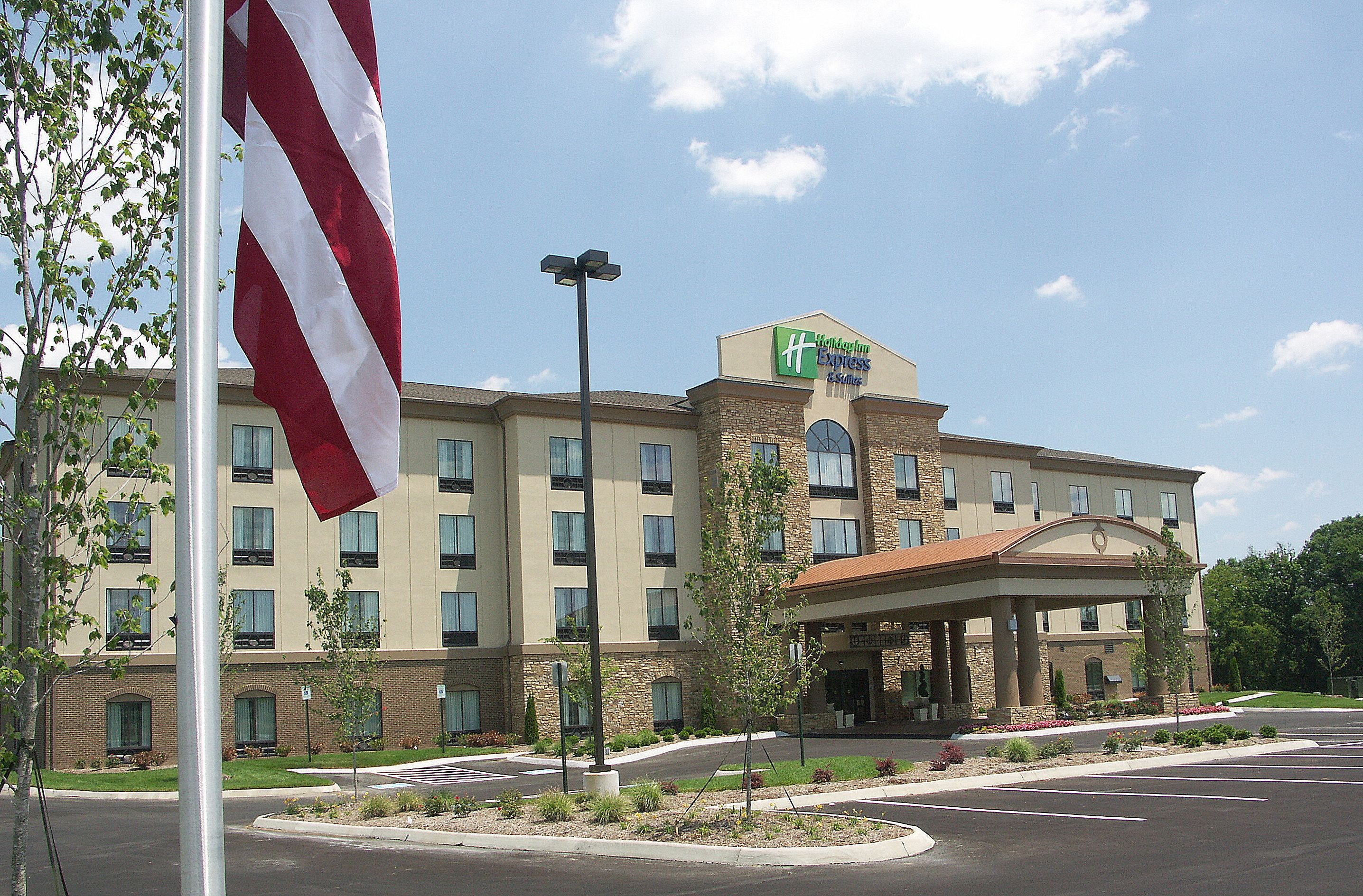 A hotel with a large American flag, a sign for Wyndham Express, and a covered entrance.