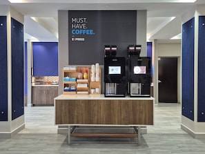 A coffee station with two espresso machines, a coffee dispenser, and a counter with various coffee-related items. - Holiday Inn Express Cleveland Northwest by IHG (Cleveland)