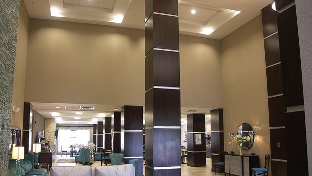 A spacious lobby with a central seating area, a reception desk, and a large mirror. - Holiday Inn Express Cleveland Northwest by IHG (Cleveland)