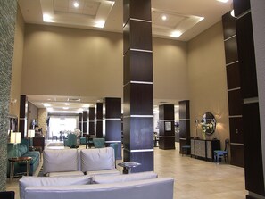 A spacious lobby with a central seating area, a reception desk, and a large mirror. - Holiday Inn Express Cleveland Northwest by IHG (Cleveland)