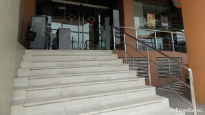A hotel entrance with a staircase leading up to a reception area. - Cityscape Hotel (Mandaue)