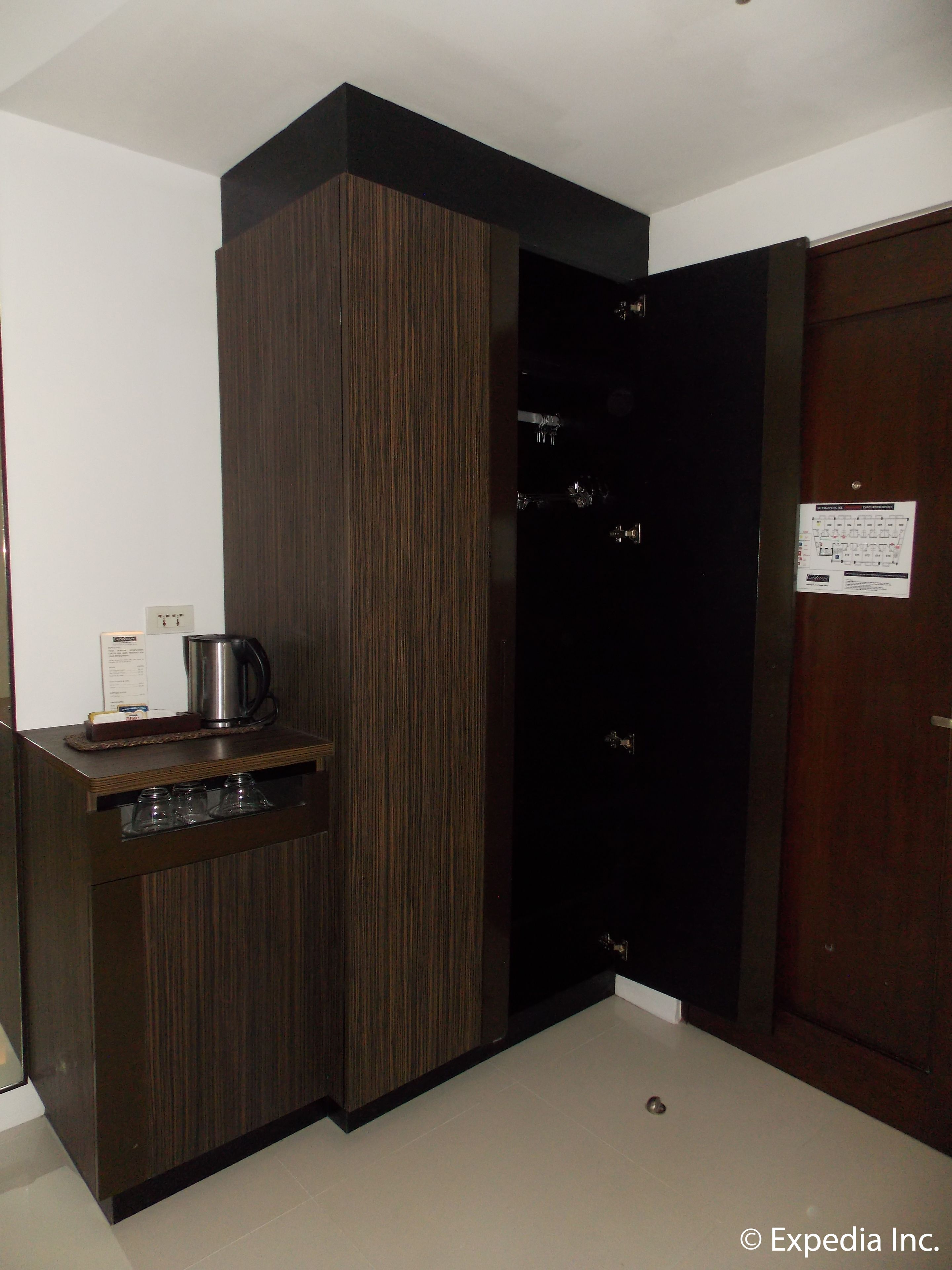 A compact kitchen area with a coffee maker, a kettle, and a small countertop.