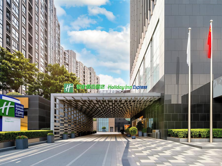 Entrada d'un hotel modern amb una taquilla d'echeck-in, un rètol de Holiday Inn Express i una gran façana de vidre.