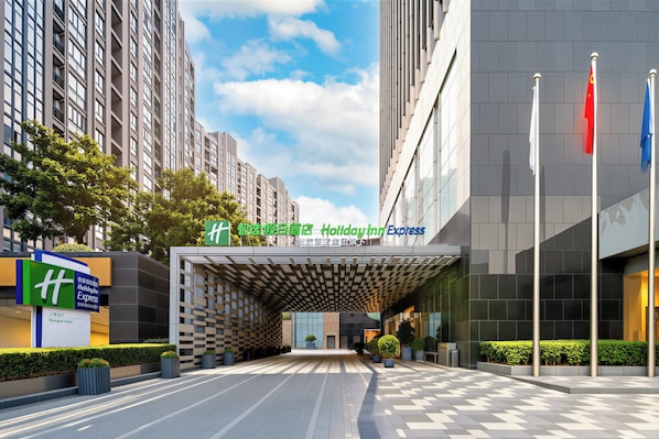 Une entrée d’hôtel moderne avec un comptoir d’enregistrement, une enseigne Holiday Inn Express et une grande façade vitrée.