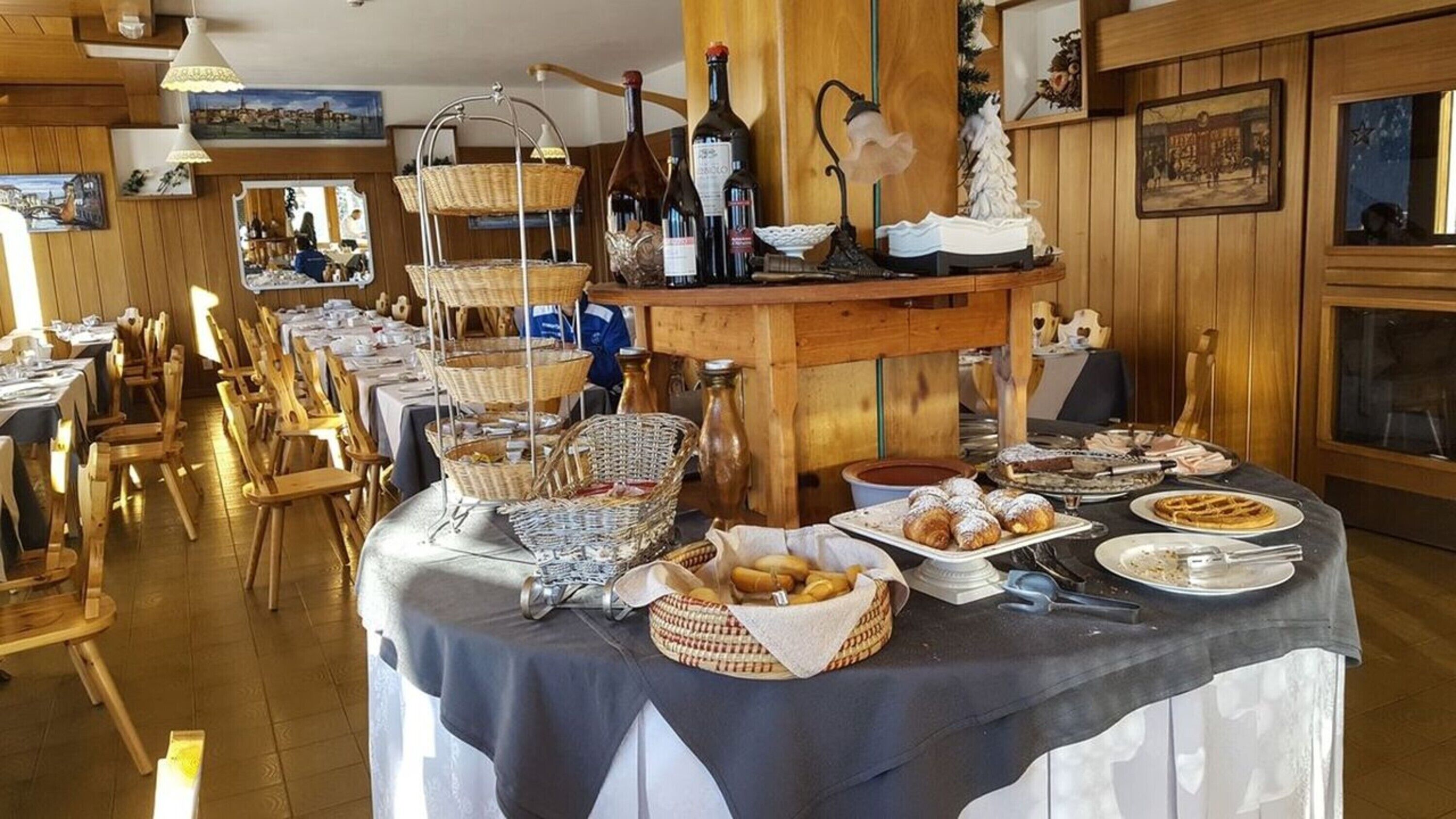 A buffet setup with various food items and wine bottles.