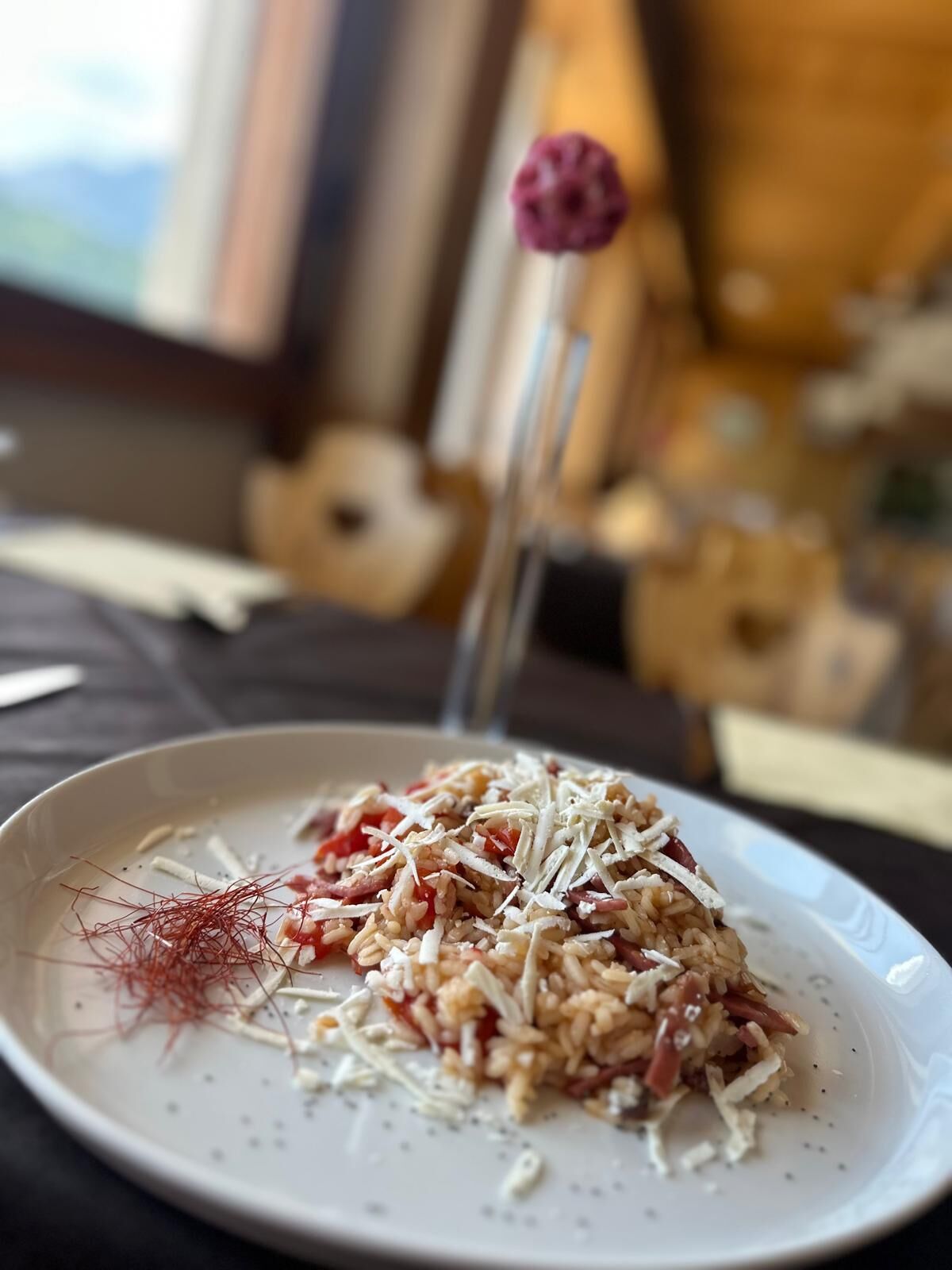 A plate of food with rice, cheese, and red garnish on a table.