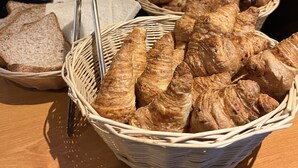 Un bufé de desayuno con pan, cruasanes y productos envasados.