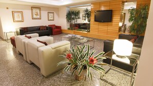 Un salon moderne comprenant un canapé, une table basse et un téléviseur fixé au mur.