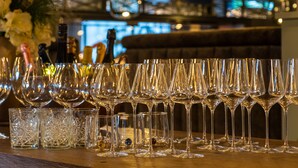 Un espace bar avec des rangées de verres et de bouteilles de vin.