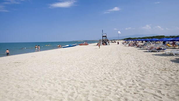 A sandy beach with a lifeguard tower, umbrellas, and boats. - TH Marina di Sibari - Baia degli Achei Village (Cassano allo Ionio)