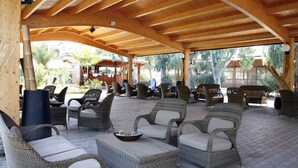 An outdoor covered patio with wicker furniture and a wooden ceiling. - TH Marina di Sibari - Baia degli Achei Village (Cassano allo Ionio)