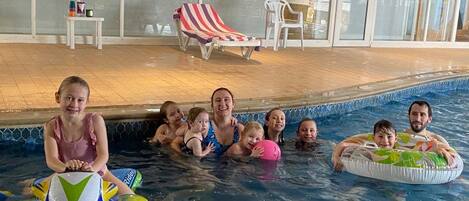 A swimming pool area with inflatable rings and a 'Happy Birthday' decoration.
