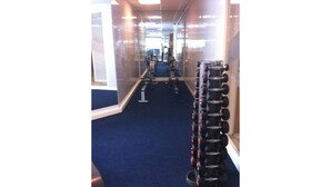Ein Fitnessraum mit Trainingsgeräten und einem blauen Teppich.