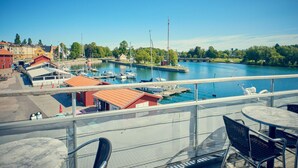 A marina with boats docked, a bridge, and buildings in the background. - Park Hotel Motala (Motala)