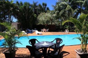 Alberca al aire libre, sombrillas en la alberca y camastros 