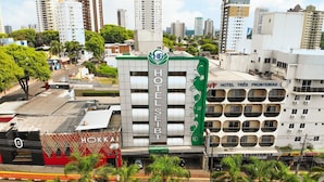 A hotel with a green and white facade, multiple balconies, and a red entrance. - Hotel Seibt (Foz do Iguaçu)