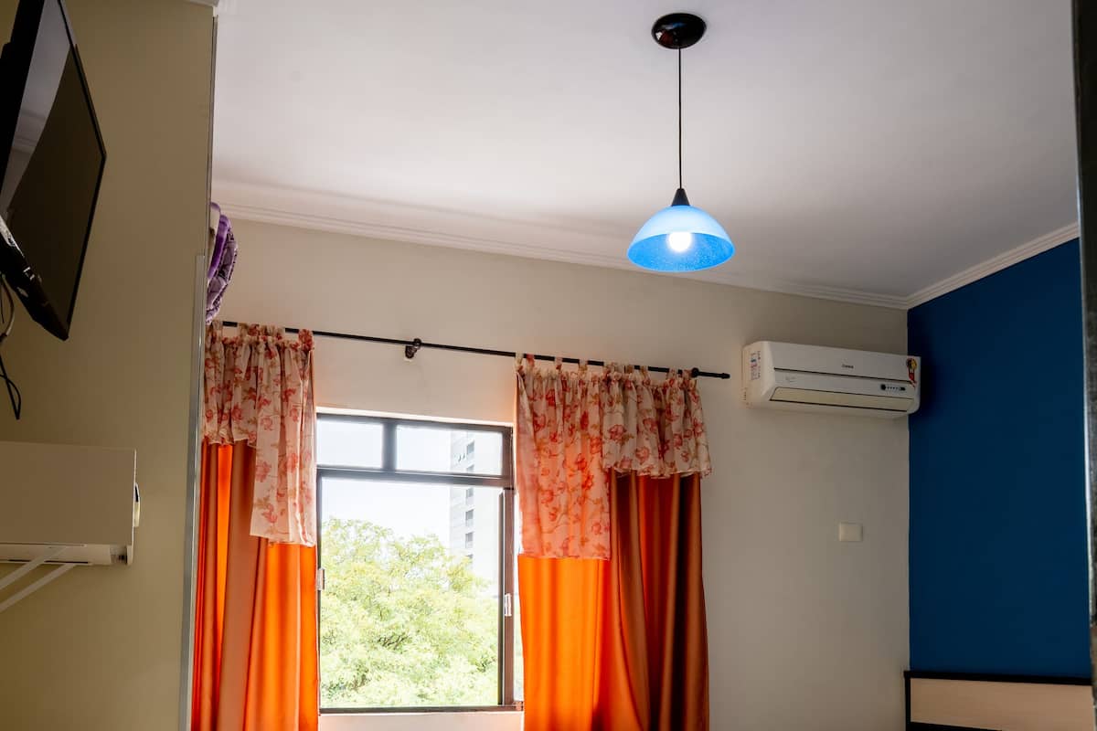 Una habitación con dos camas, un escritorio y una ventana con cortinas.
