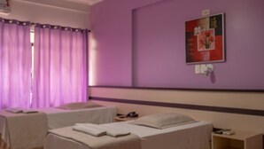 A room with two beds, a wooden floor, and a purple wall. - Hotel Seibt (Foz do Iguaçu)