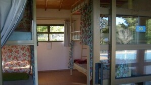 Un dormitorio con literas, una ventana y una puerta con un número.