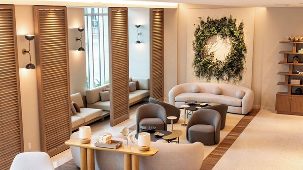 A modern living room with a sofa, armchairs, a coffee table, and a decorative wall.