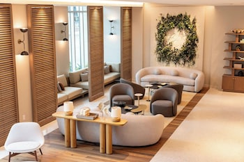 A restaurant with wicker pendant lighting, wooden tables, and a modern interior design. at Live Oak, Charleston Historic District, a Tribute Portfolio Hotel