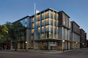 A gym with treadmills aligned along a wall with large windows. at Live Oak, Charleston Historic District, a Tribute Portfolio Hotel