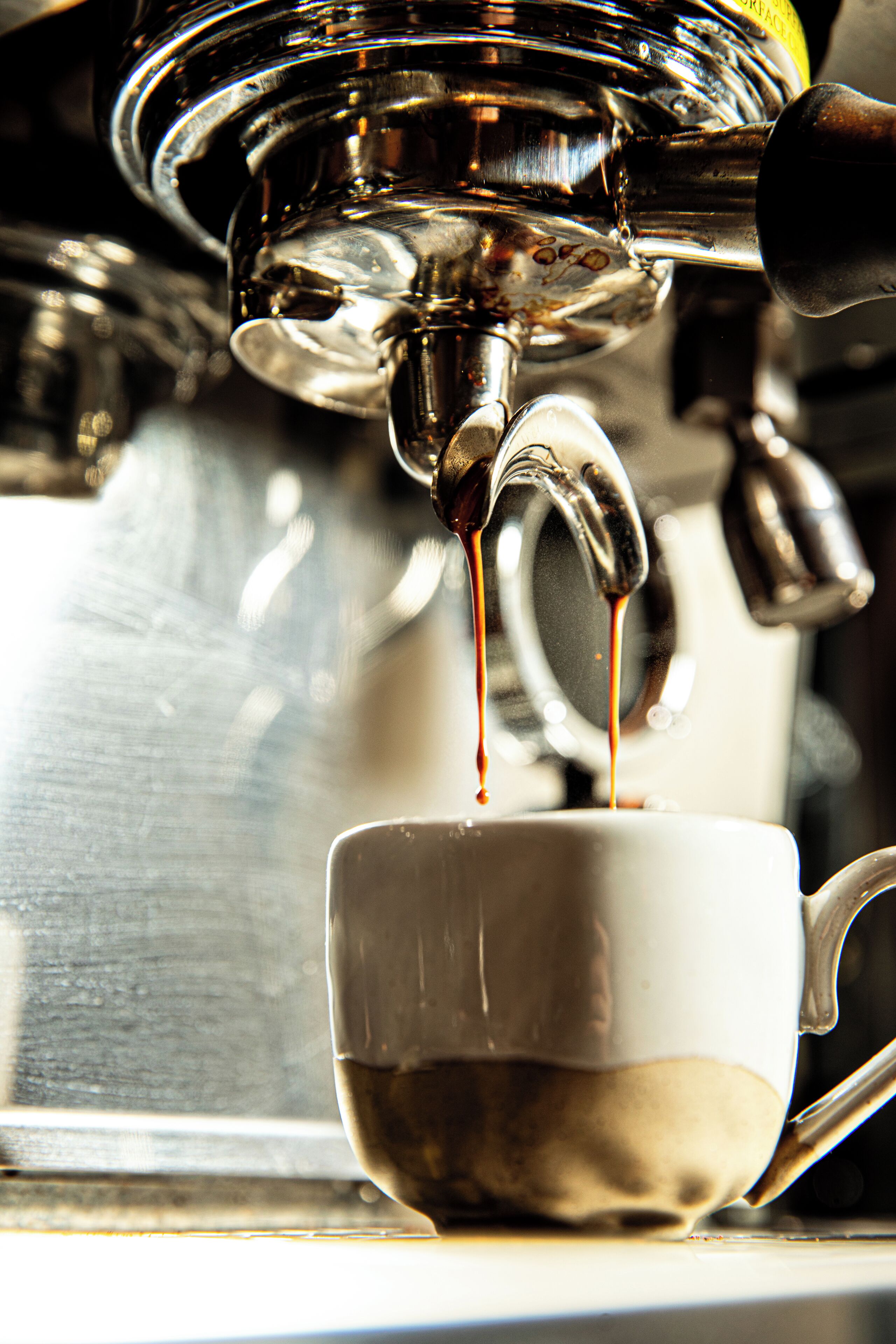 A close-up of a coffee machine dispensing espresso into a cup.