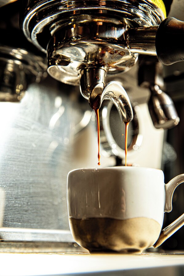 A close-up of a coffee machine dispensing espresso into a cup.