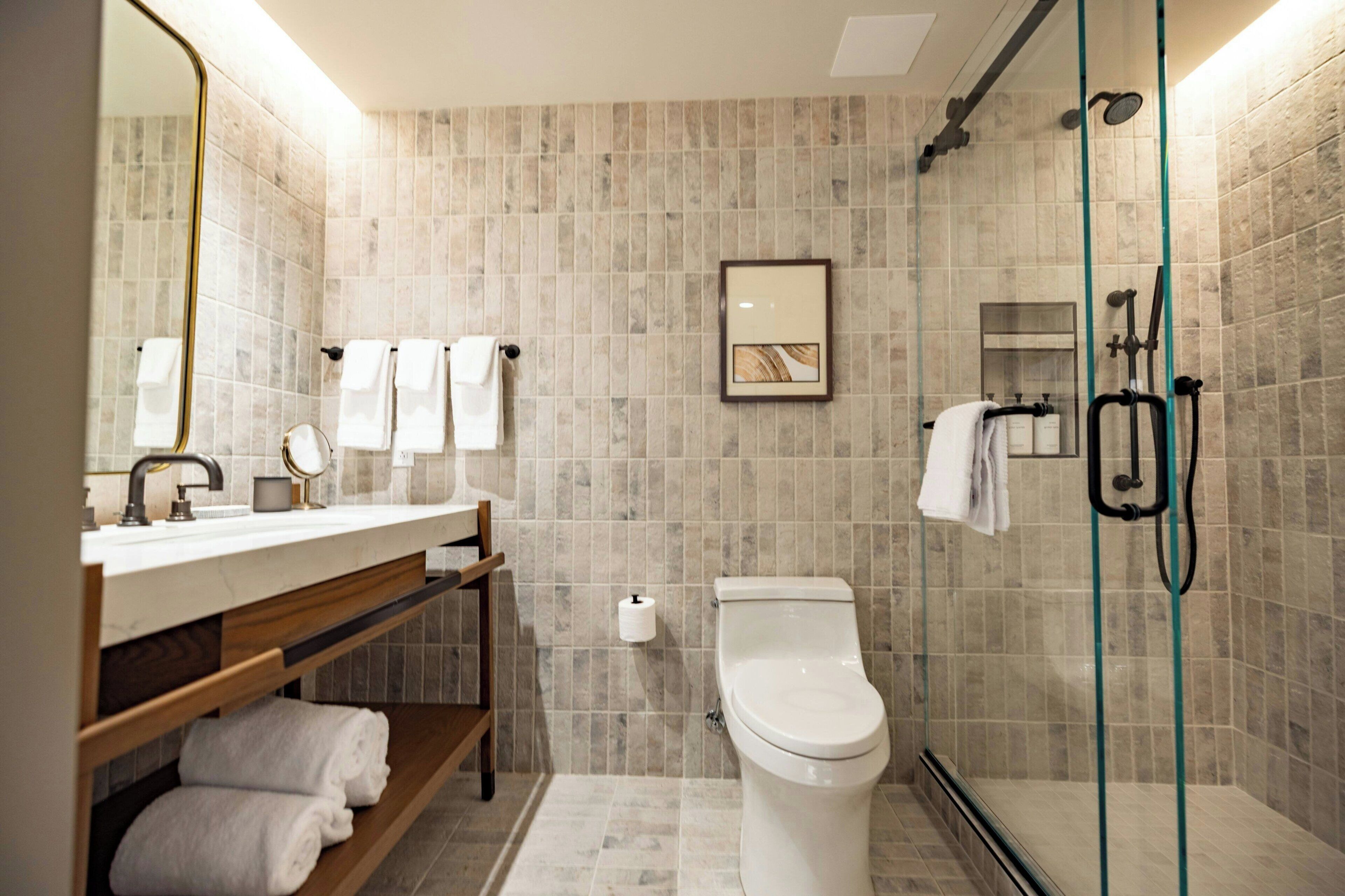 A modern bathroom with a toilet, sink, and shower area.