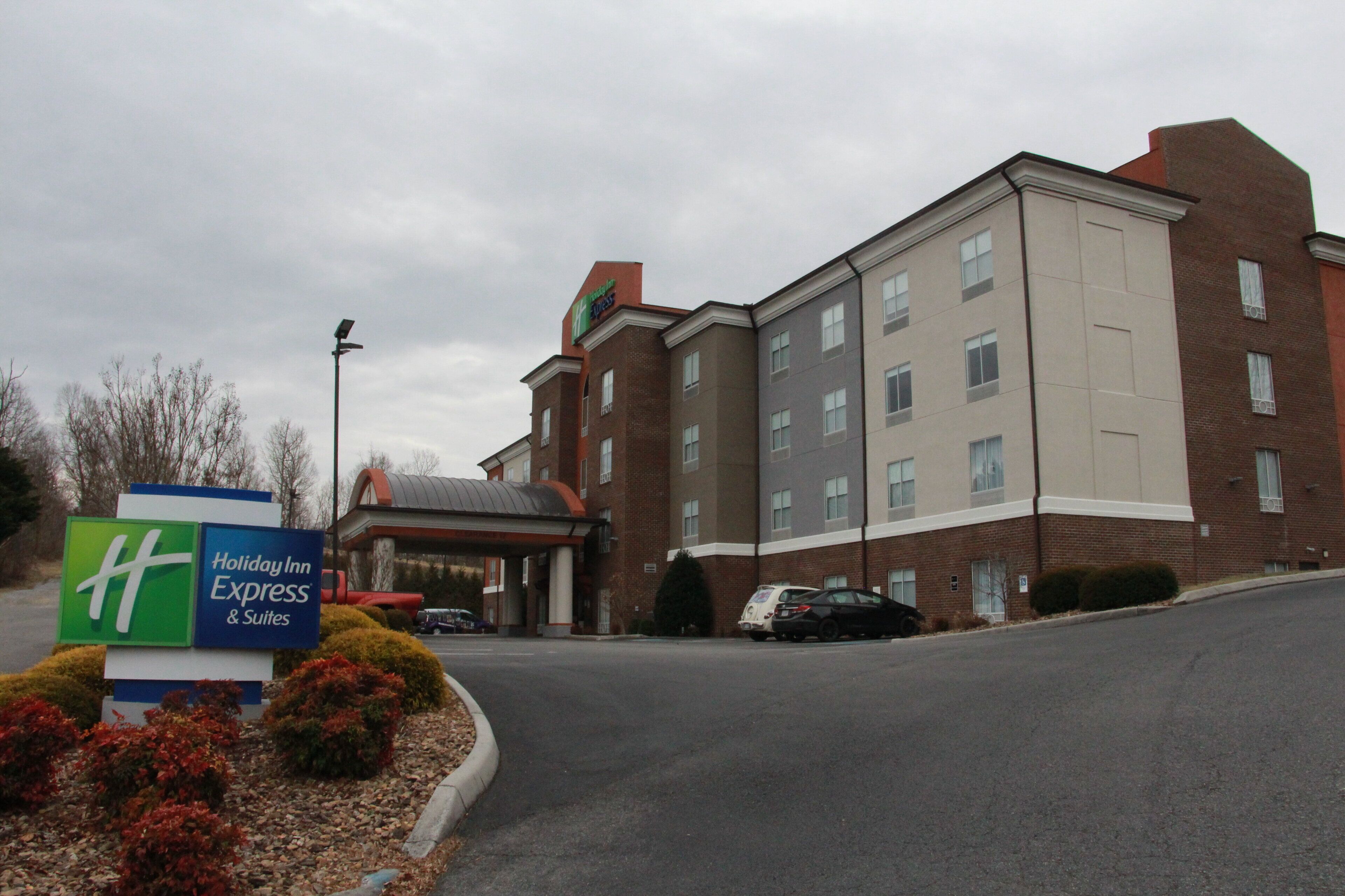A Holiday Inn Express & Suites building with a brick facade and a covered entrance.