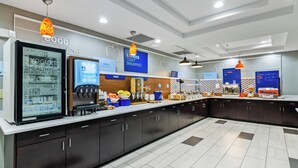 A modern kitchen area with a refrigerator displaying yogurt and milk, a coffee machine, and a counter with various food items and utensils. - Holiday Inn Express and Suites Wytheville by IHG (Wytheville)