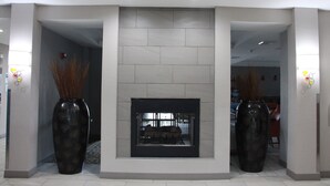 A modern lobby with a fireplace, two large vases, and a tiled floor. - Holiday Inn Express and Suites Wytheville by IHG (Wytheville)
