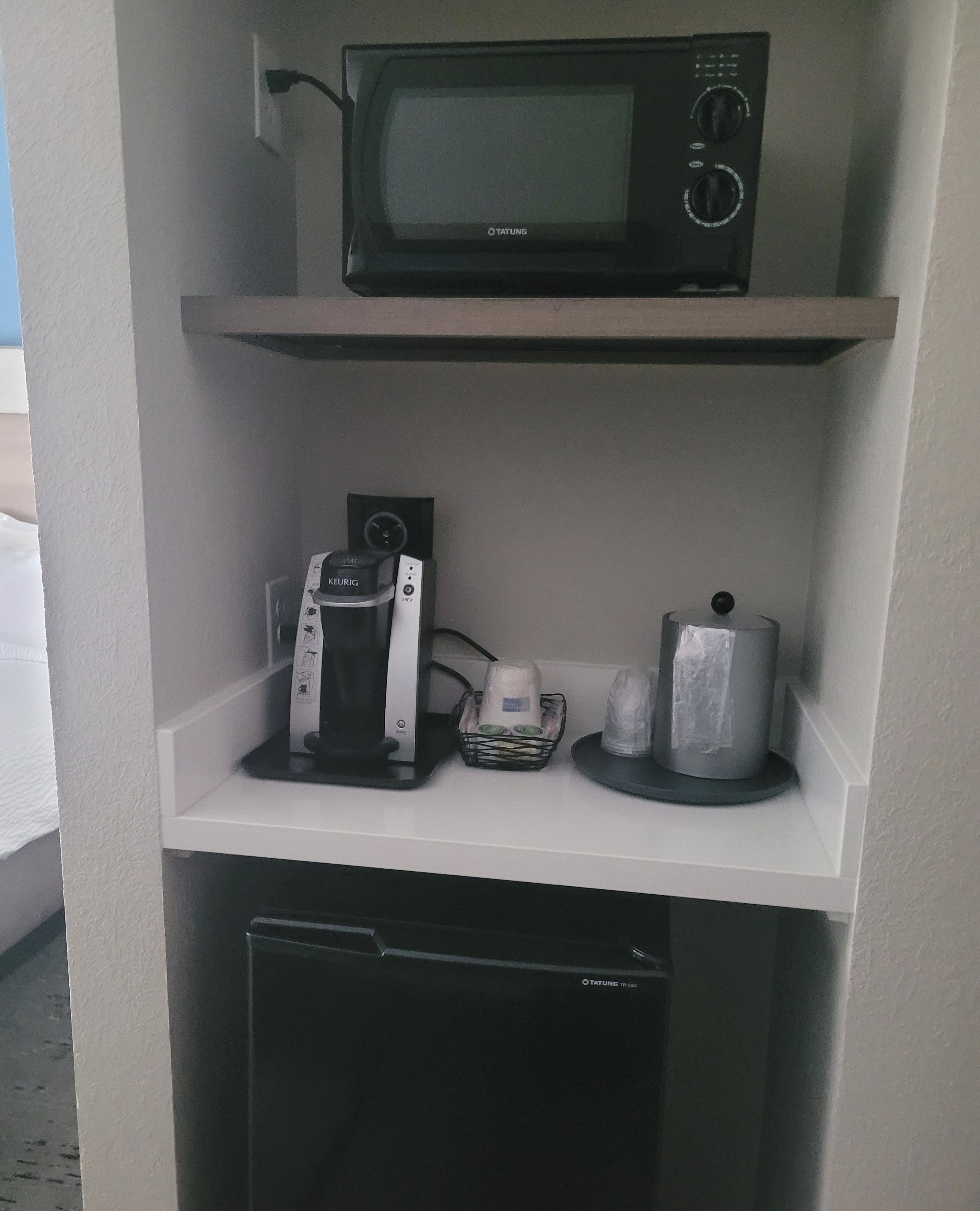 A kitchenette with a microwave, coffee maker, and a small refrigerator.