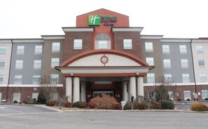 Edificio de Holiday Inn Express & Suites con fachada de ladrillo, ventanas grandes y una entrada central con columnas.