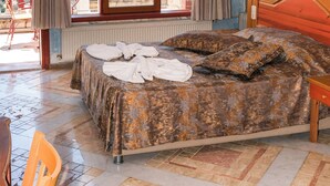 A hotel room with a bed, a chair, a window with a view, a radiator, and a ceiling light. - Villa Symbola (Fethiye)