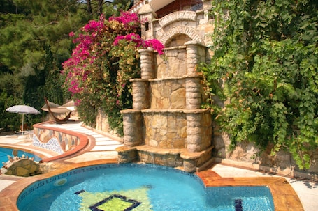 Una piscina al aire libre, sillones reclinables de piscina