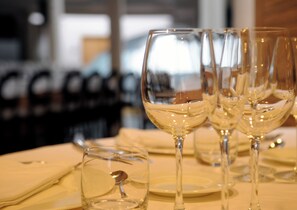 A table set with multiple wine glasses and a small glass with a spoon, indicating a dining setting. - Cumbria Spa&hotel (Ciudad Real)