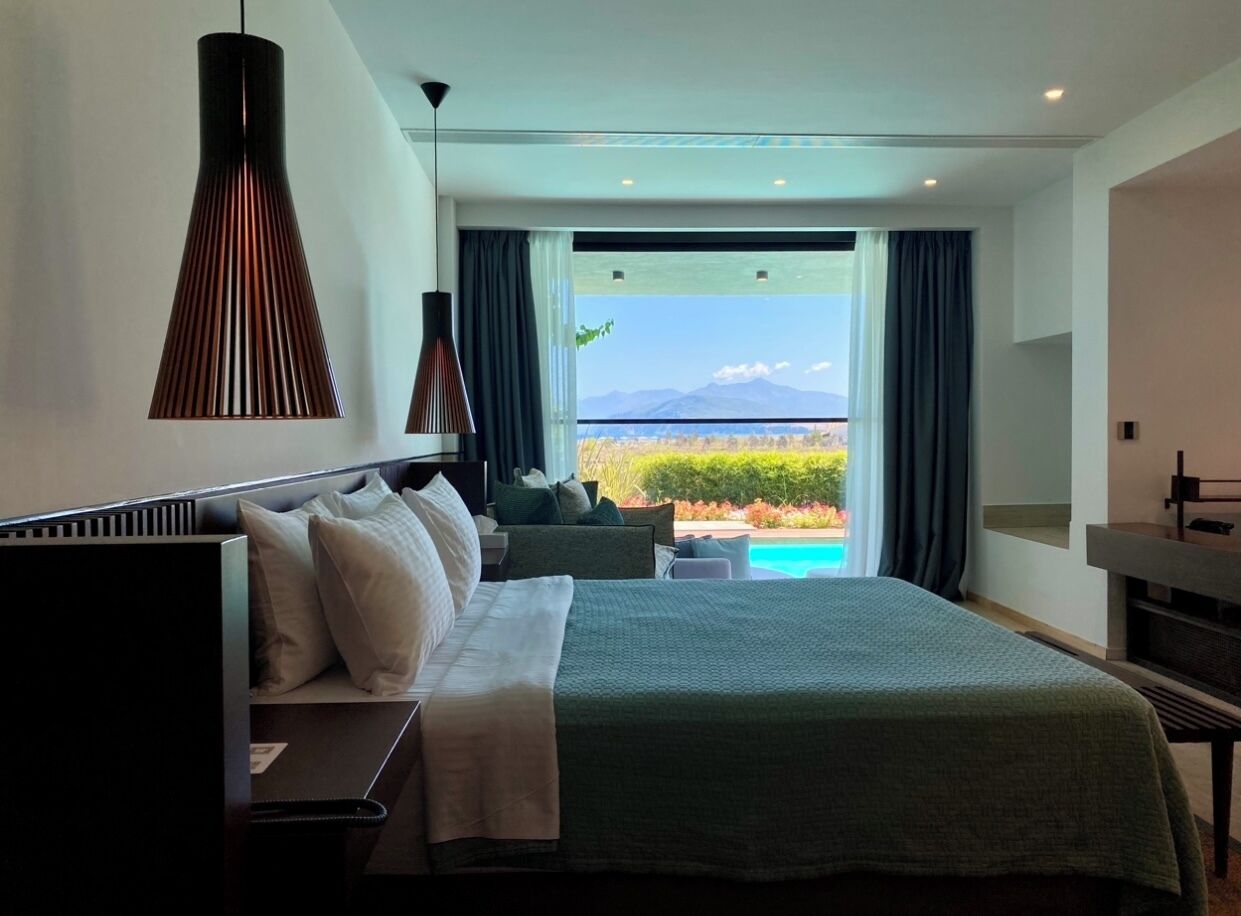Una habitación de hotel moderna con una cama grande, un escritorio y vistas al océano.