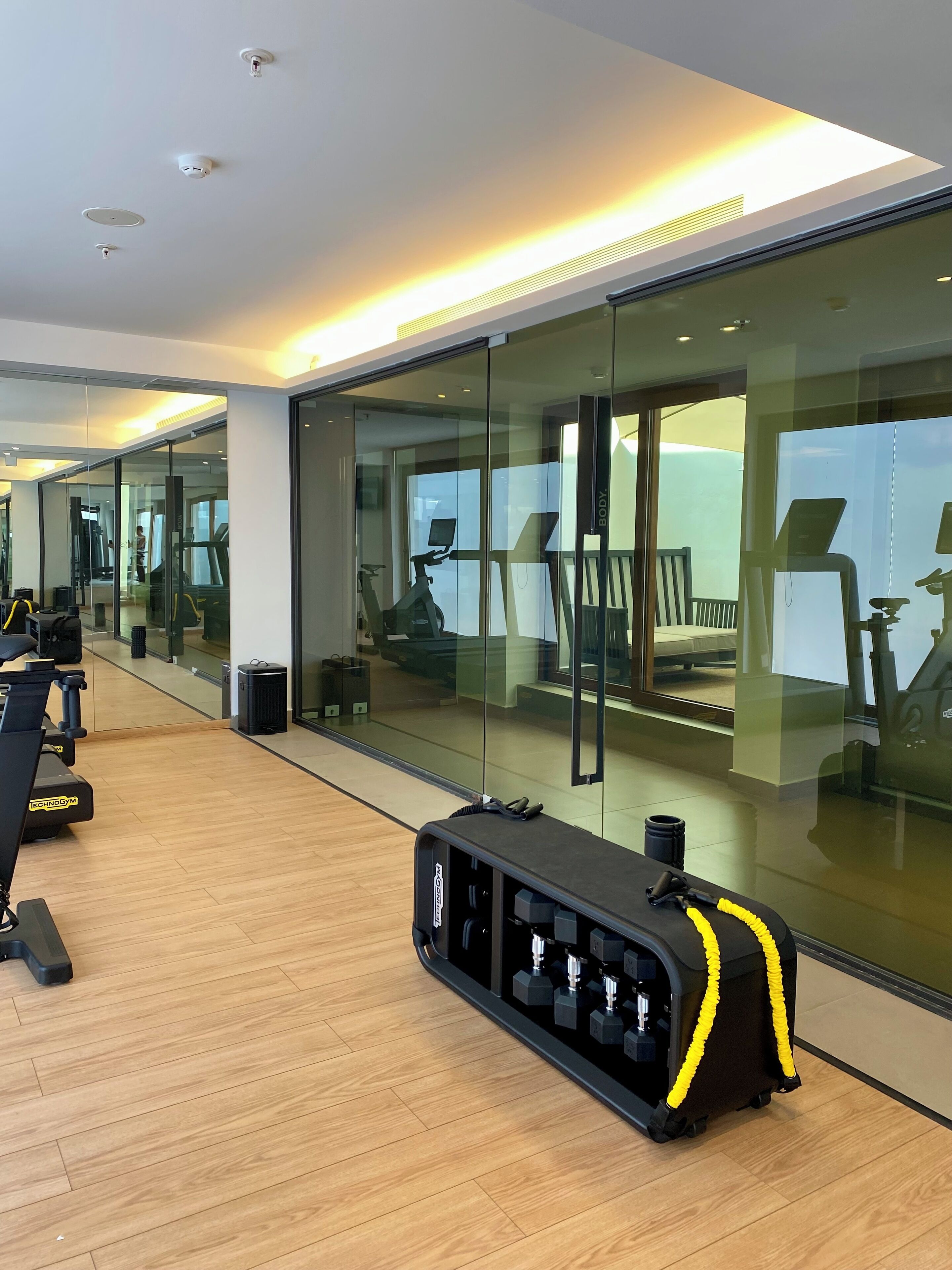 A modern gym with exercise equipment, a treadmill, and a weightlifting station.