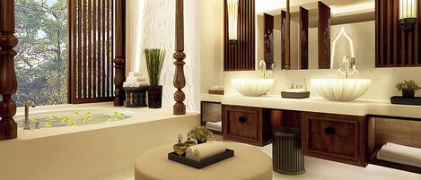 A modern bathroom with a large bathtub, two sinks, and a vanity with a mirror.
