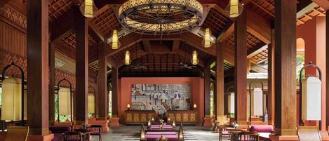 A spacious hall with high wooden ceilings and ornate chandeliers.