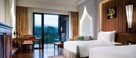 A hotel room with two beds, a balcony, a dining area, and a view of the outdoors.